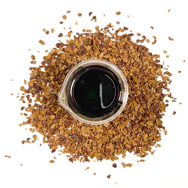 Dried hawthorn berries surround a beaker containing NATIVE EXTRACTS Hawthorn Berries Cellular Extract, deep brown to black in colour