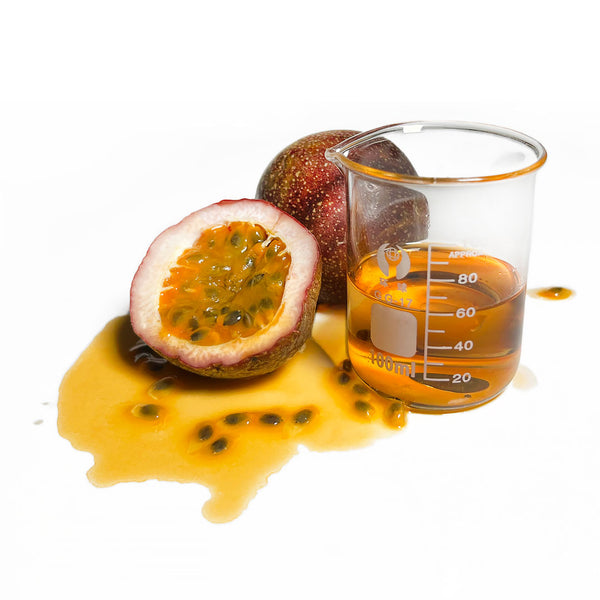 Two passionfruits sit, with their seeds and juice on the counter. Next to them is a beaker of the Native Extracts Passionfruit Cellular Extract.